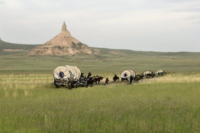 Historia osadników z West Conquete: Amerykańscy pionierzy. Podróże kilku rodzin przez równiny Stanów Zjednoczonych. Diligences przekraczania Chimney Rock na szlaku Oregon, Nebraska. Kolorowa rycina w połączeniu z fotografią. autorstwa Unbekannter Künstler