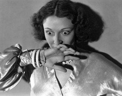 Hollywood, Kalifornia: c.1932 Zbliżenie młodej kobiety zakrywającej usta ze strachu. (zdjęcie czarno-białe) autorstwa Unbekannt