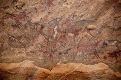 Sztuka naskalna, prehistoria: Malowidło naskalne przedstawiające grupę bydła i polichromowane postacie w ozdobnym schronie w masywie Uweinat w Sudanie. Okres od 8000 do 3000 lat pne. Fotografia autorstwa Unbekannt