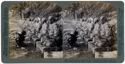 Chłop modlący się przed rzędem posągów Boga Światła, rzeka Daiya, Nikko, Japonia, 1904. autorstwa Underwood and Underwood