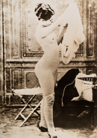 Pełnometrażowy nagi portret młodej kobiety ubierającej się. autorstwa Unknown photographer