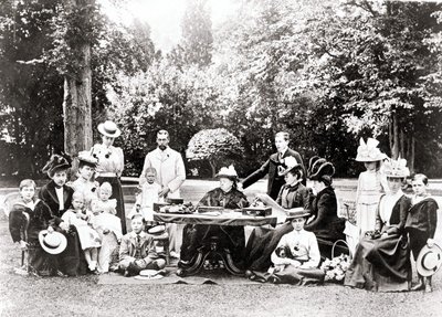 Członkowie brytyjskiej rodziny królewskiej, w tym król Jerzy V, król Edward VIII wokół królowej Wiktorii na przyjęciu w ogrodzie. Fotografia w latach 1895-1901. autorstwa Unknown photographer