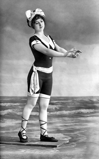Kobieta w kostiumie kąpielowym i butach plażowych. autorstwa Unknown photographer