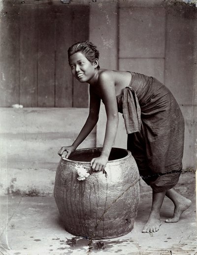 Młoda uśmiechnięta Tajka pchająca duży kontener autorstwa Unknown photographer