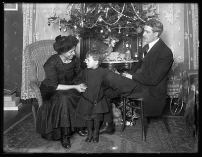 Dan Seymour i rodzina w nieformalnej pozie, siedzący pod choinką, Boże Narodzenie 1912 autorstwa William Davis Hassler