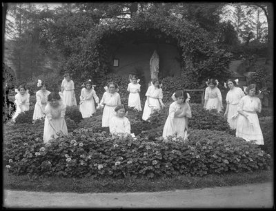 Klasa maturalna dziewcząt z rzymskokatolickiego azylu dla sierot w ogrodzie kwiatowym, przed grotą Marii Panny, fot. 1912 bw autorstwa William Davis Hassler