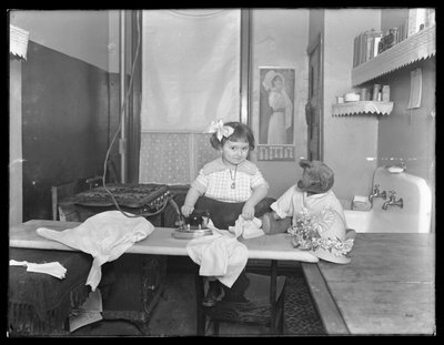Niezidentyfikowana dziewczynka demonstrująca użycie żelazka elektrycznego, ok. 1913-14 autorstwa William Davis Hassler