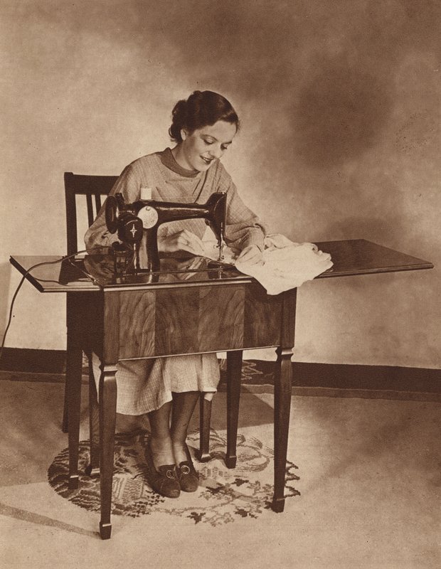 Gospodyni domowa przy maszynie do szycia, połowa lat 30. XX wieku (zdjęcie czarno-białe) autorstwa English Photographer