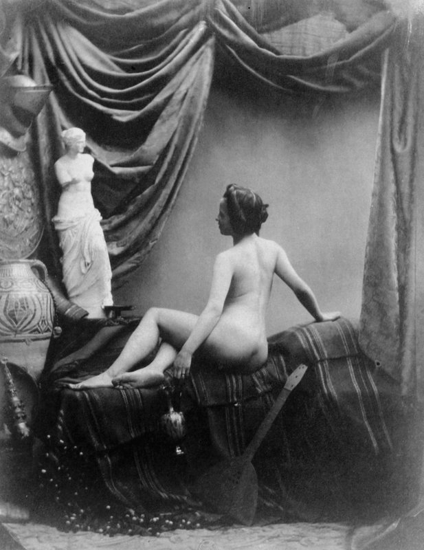 Naga kobieta podziwiająca figurę Wenus z Milo (zdjęcie czarno-białe) autorstwa European Photographer