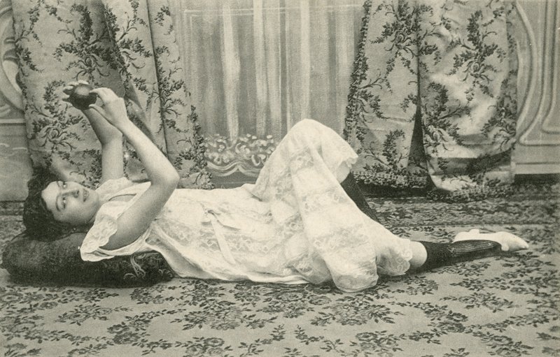 Dziewczyna leżąca na podłodze trzymająca piłkę nad głową (zdjęcie czarno-białe) autorstwa French Photographer