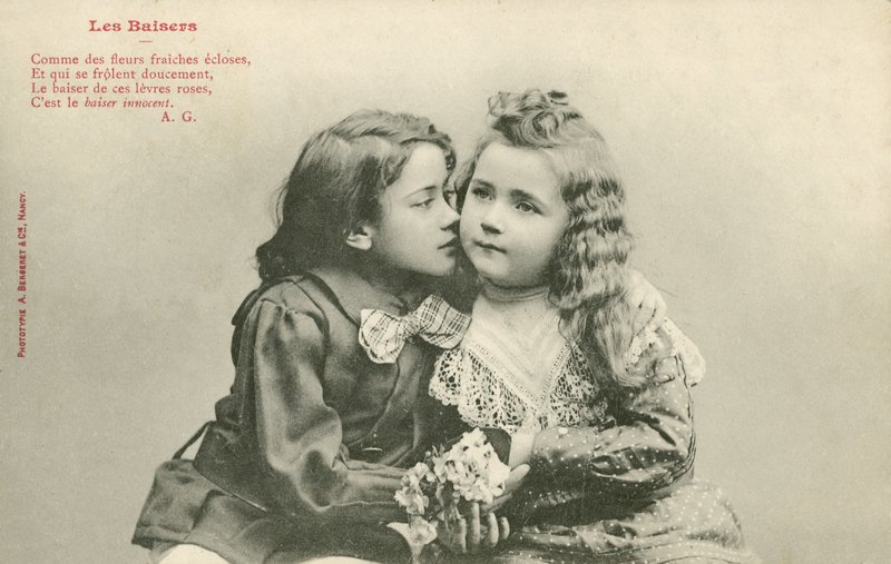 Mały chłopiec całujący małą dziewczynkę (zdjęcie czarno-białe) autorstwa French Photographer