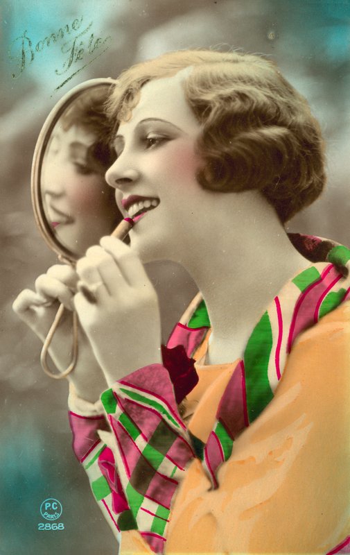 Ładna dziewczyna nakładająca szminkę, używając lusterka autorstwa French Photographer