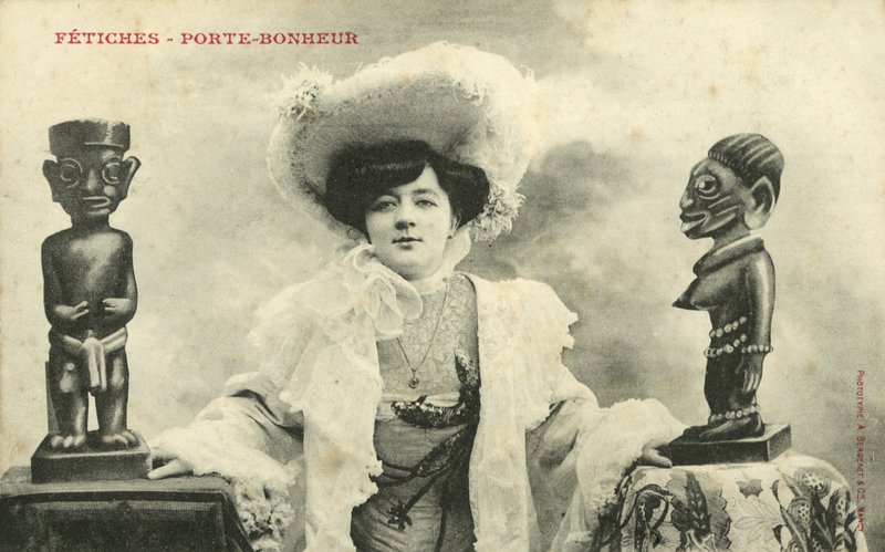Kobieta z afrykańskimi statuetkami (zdjęcie czarno-białe) autorstwa French Photographer
