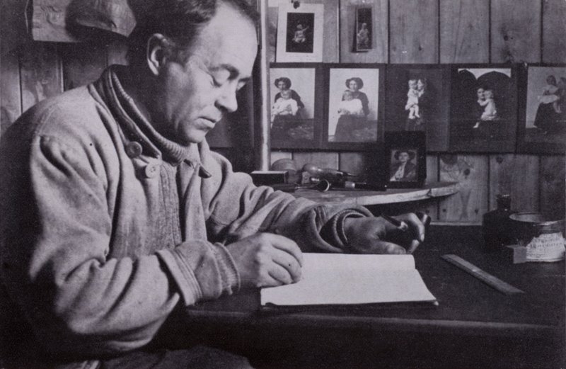 „Scott pisał, planował i kalkulował przy swoim stoliku” (zdjęcie czarno-białe) autorstwa Herbert Ponting