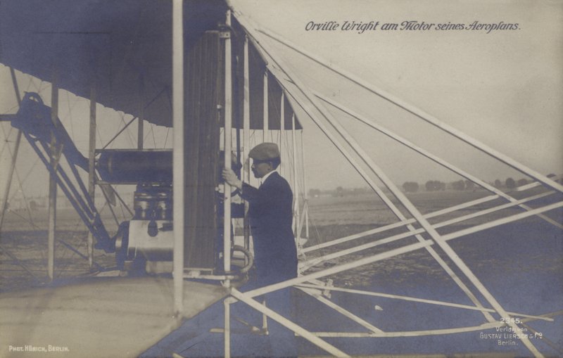 Amerykański lotnik Orville Wright podczas inspekcji silnika swojego samolotu (zdjęcie czarno-białe) autorstwa Photographer German