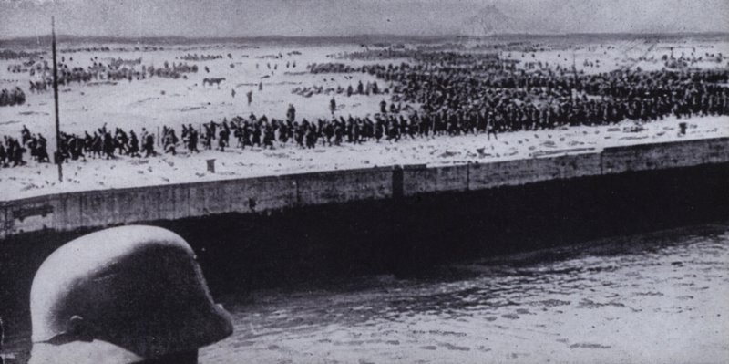 Niemiecki żołnierz mierzący jeńców alianckich na plaży w Dunkierce, Francja, II wojna światowa, czerwiec 1940 (zdjęcie czarno-białe) autorstwa Photographer German