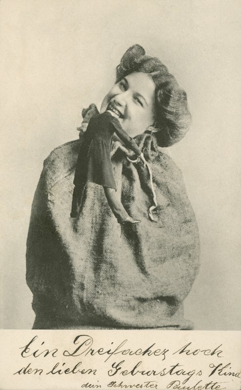 Kobieta odgryzająca głowę lalce (zdjęcie czarno-białe) autorstwa Photographer German