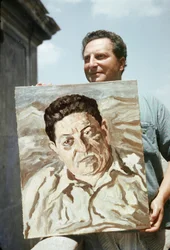 Włoski malarz i pisarz Carlo Levi (1902-1975) trzymający jedno ze swoich dzieł, portret związkowca Giuseppe di Vittorio (zdjęcie)
