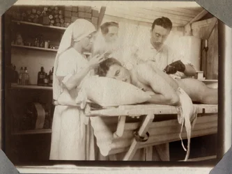 Pierwsza wojna światowa 1914-1918: lekarze i pielęgniarka opatrują rany żołnierza w sali opatrunkowej w obozie Couville w departamencie Manche, Dolna Normandia, Francja. Fotografia anonimowa, lipiec 1917. Kolekcja prywatna Stella.