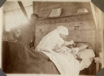 Pierwsza wojna światowa 1914-1918: pielęgniarka w bluzie goli żołnierza (rany wojenne leżą w łóżku), w Couville, Manche, Dolna Normandia (Dolna Normandia), Francja. Anonimowe zdjęcie z lipca 1917. Zbiory prywatne, Stella.