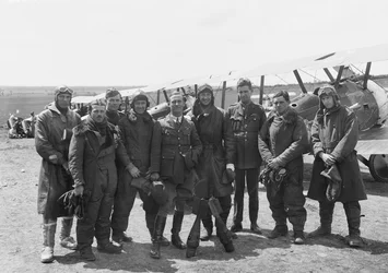 Funkcjonariusze A Flight, 4. Eskadry Australijskiego Korpusu Lotniczego (AFC), w pełnym rynsztunku lotniczym przed szeregiem samolotów Sopwith Camel, 16 czerwca 1918