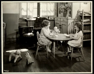 Dwie niewidome, niedowidzące dziewczyny jedzące przy małym stoliku z lalką w nowojorskim stowarzyszeniu dla niewidomych, 111 East 59th Street, Nowy Jork, 1933 (srebrny odbitka żelatynowa)