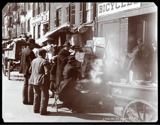 Widok ulicznych sprzedawców, w tym jednego, który pokazuje fotograficzne widoki egzotycznych miejsc w oknie widokowym, na Bayard Street, Nowy Jork, 1898 (srebrny odbitka żelatynowa)