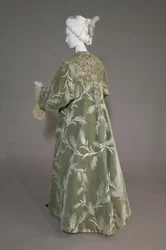 Płaszcz wieczorowy Berthy Palmer, ok. 1902 (widok z tyłu ukośnie). Jedwabna satyna z ciętym aksamitem w pszeniczny wzór, metaliczna nić koronkowa, jedwabne metaliczne frędzle. Warto, Paryż.