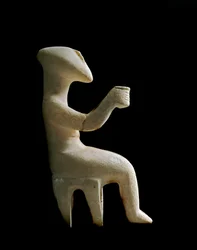 Sztuka Cyklad: „Figurka siedząca na stołku”. Marmurowy idol inkrustowany ochrą. Cywilizacja cykladzka (-3200 do -2000). Wysokość 15.2 cm. Ateny, Narodowe Muzeum Archeologiczne (nr inw. 3910)