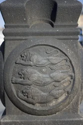 Symbol trzech lwów wyrzeźbiony w kamiennej kolumnie na Placu Ratuszowym