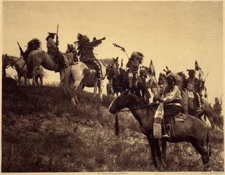 Planowanie nalotu. Indianie w swoich imponujących typowych strojach spotykają się w niezwykle malowniczych grupach. To oddział z Sioux Ogalala (Oglala), na wzgórzu z widokiem na dolinę Wounded Knee w rezerwacie Pine Ridge w Południowej Dakocie. zdjęcie