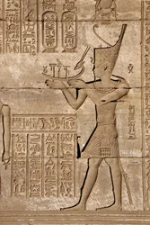 Starożytność egipska: Mammisi rzymskie upamiętniające narodziny Ihy, syna Izydy - Fragment płaskorzeźb i hieroglifów, Świątynia Hathor, Denderah, Egipt - Cywilizacja egipska: człowiek niosący symboliczną korę, fragment mammisi rzymskiej, upamiętniający nar