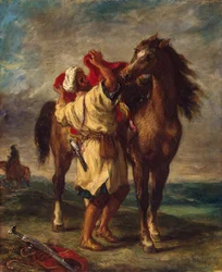 Arab siodłający konia