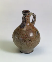Butelka wina Bartmannkrug lub Bellarmine ozdobiona brodatą maską na twarz, Niemcy, ok. 1630-40 (kamionka glazurowana solą)