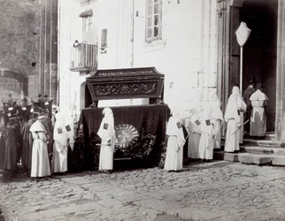 Procesja żałobna Zgromadzenia św. Franciszka w Neapolu. Na pierwszym planie, przed kościołem, liczni „bracia bractwa” w białych tunikach i kapturach towarzyszą katafalkowi ozdobionemu haftowanym płótnem, na którym umieszczona jest trumna