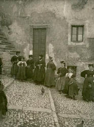 Kobiety i dzieci w tradycyjnych strojach na schodach prowadzących do domu, Abruzja, Włochy
