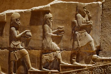 Rzeźba reliefowa przedstawiająca mężczyzn niosących ofiary na murach Persepolis. Persepolis, Iran.
