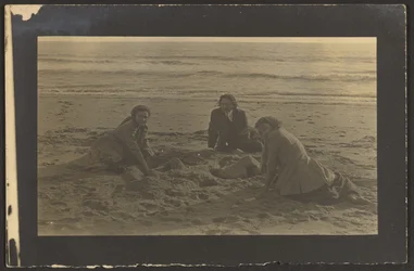 [Postacie siedzące na plaży]