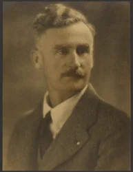 [Portret mężczyzny z białą przypinką do klapy].