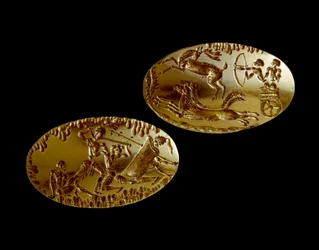 Sztuka mykeńska: dwie złote pieczęcie z przedstawieniem sceny polowania na czołgu oraz wojownika stającego naprzeciw trzech przeciwników. 1550-1100 p.n.e. z grobowca IV w Mykenach. Narodowe Muzeum Archeologiczne w Atenach (inw. 240 i 241)
