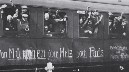 I wojny światowej wojska niemieckie wyjeżdżają na front w wagonie kolejowym z napisem „Z Monachium przez Metz do Paryża”, wrzesień 1914 (zdjęcie czarno-białe)