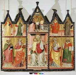 Poliptyk Matki Boskiej z Dzieciątkiem i Świętymi. U góry po lewej: Święta Katarzyna Aleksandryjska i Święta Maria Magdalena. W centrum wokół Chrystusa na krzyżu z napisem „INRI”” (I.N.R.I.). Maryi Panny i św. Jana. U góry po prawej: S