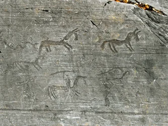 Prehistoria, cywilizacja Kamunów, sztuka naskalna: rytowana skała ze sceną polowania, myśliwy wymachuje włócznią. Okres między neolitem a epoką brązu. Capo di Ponte, Park Narodowy Rytów Naskalnych w Naquane, Valcamonica, Val Camonica, Włochy