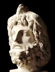 Sztuka rzymska: „”broda głowa pokryta martwym ptakiem Sarapis lub Serapis, grecko-egipski bóg śmierci””” Rzeźba z marmuru z Kartaginy. II wiek. Ciemny. 60 cm Paryż, Musee du Louvre