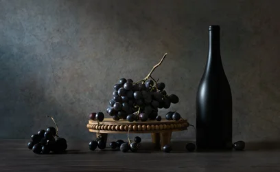 Ciemna butelka z motywem bogatych winogron