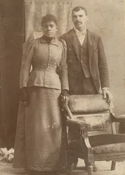 Zdjęcie afroamerykańskiej pary stojącej za krzesłem, ca. 1890.