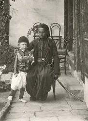 Arabski kawass (osmański strażnik) z młodym chłopcem w ogrodzie domu w dzielnicy Judea w Jerozolimie, 1867 r.