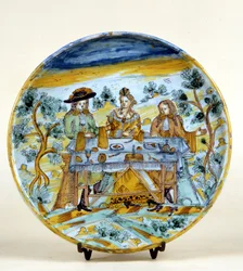 Przedstawienie bankietu plenerowego na talerzu ceramicznym Talavera de la reina (Hiszpania). Początek XVI wieku. Mediolan, Museo del Castello.