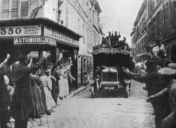 Brytyjscy żołnierze są mile widziani, gdy przybywają furgonetką do francuskiego miasta, 1915 r