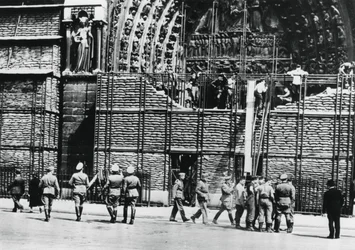 Oczyszczanie worków z piaskiem z fasady katedry Notre Dame, okupowany przez Niemców Paryż, 1940